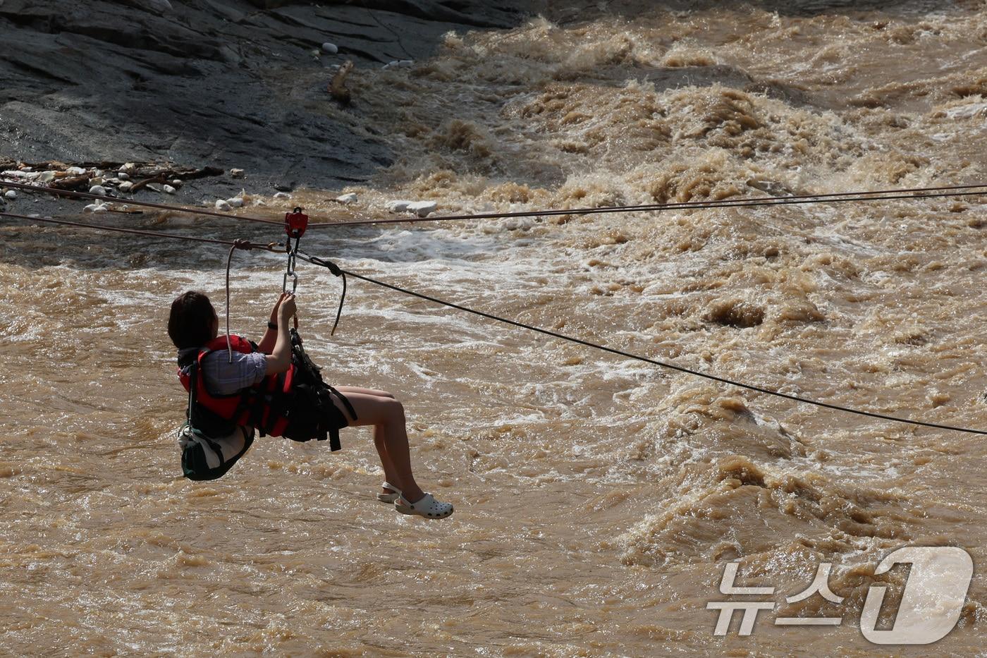 20일 경기 가평군 마일리의 한 캠핑장에 고립된 시민들이 소방 로프를 타고 탈출하고 있다. 2025.7.20/뉴스1 ⓒ News1 신웅수 기자