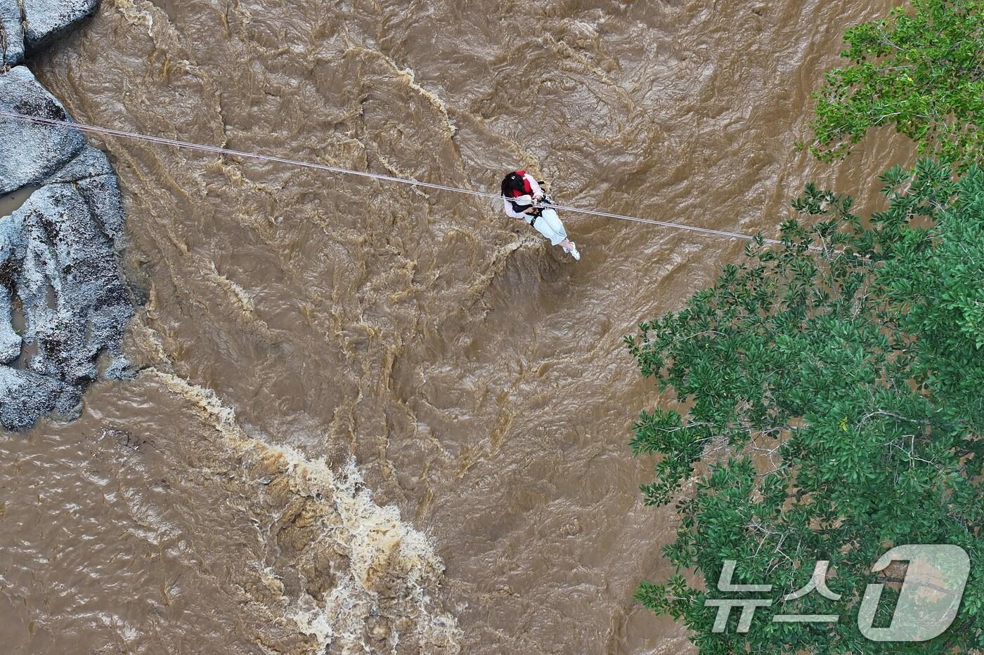 20일 경기 가평군 마일리의 한 캠핑장에 고립된 시민들이 소방 로프를 타고 탈출하고 있다. 2025.7.20/뉴스1 ⓒ News1 신웅수 기자