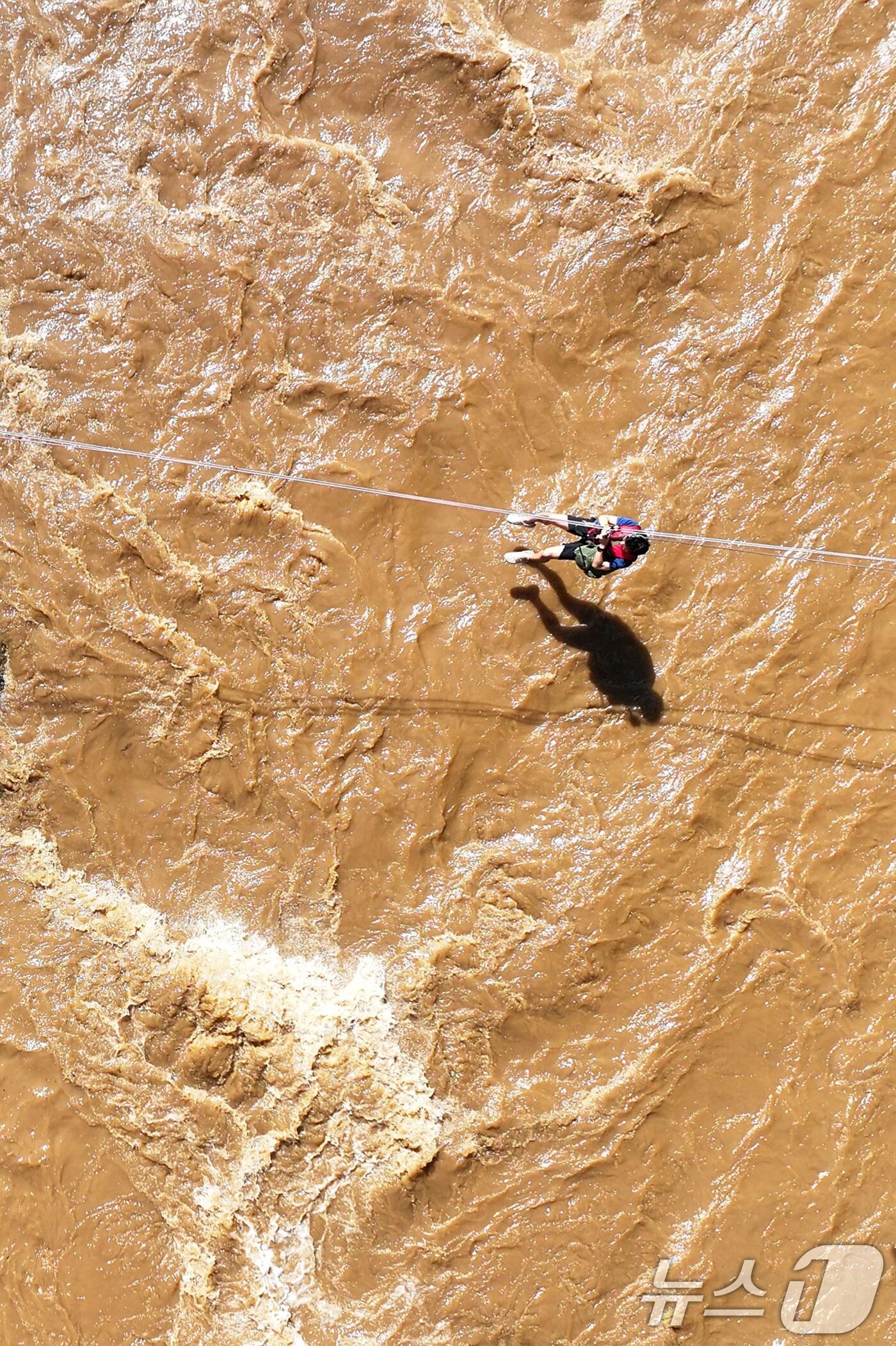 본문 이미지 - 20일 경기 가평군 마일리의 한 캠핑장에 고립된 시민들이 소방 로프를 타고 탈출하고 있다. 2025.7.20/뉴스1 ⓒ News1 신웅수 기자