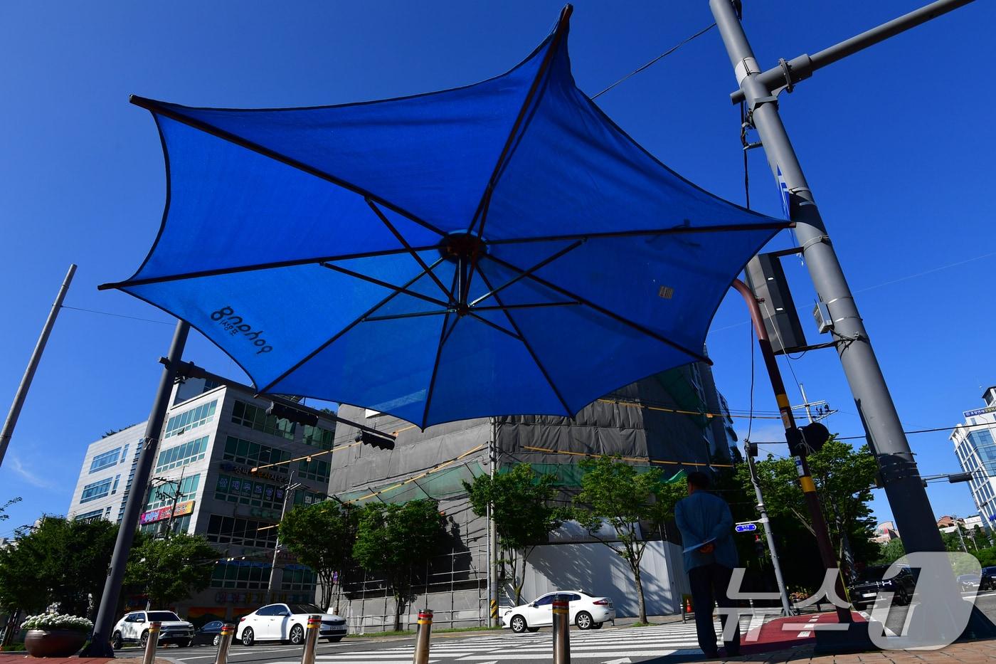 21일 오전 출근길에 니선 시민이 대형 우산 그늘막 밑에서 햇볕을 피하고 있다. 2025.7.21/뉴스1 ⓒ News1 최창호 기자