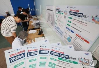 본문 이미지 - '민생회복 소비쿠폰'의 1차 신청 첫날인 21일 오전 경기 수원시 팔달구 인계동행정복지센터에서 시민들이 신청서를 작성하고 있다. 2025.7.21/뉴스1 ⓒ News1 김영운 기자