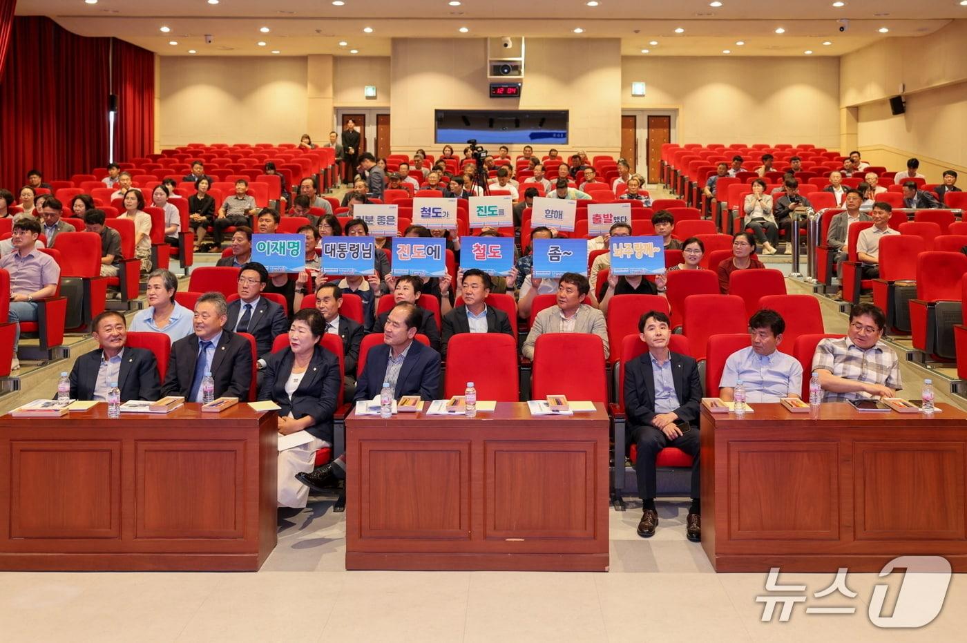 진도군 철도 용역 보고회 참석자들이 '이재명 대통령님 진도에 철도 좀 놔주랑께'라는 피켓을 들고 용역 결과 발표를 듣고 있다. (진도군 제공, 재판매 및 DB 금지)/뉴스1
