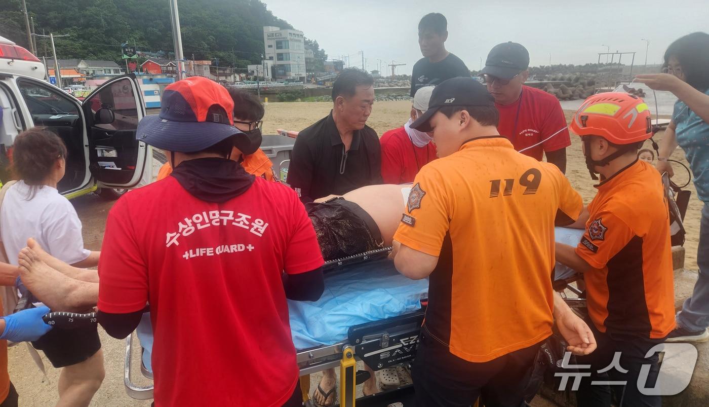 지난 19일 경북 영덕군 하저리해수욕장에서 의식을 잃고 쓰러진 중국인 관광객을 수상인명구조요원들이 응급처치 후 병원으로 이송하고 있다. (영덕군 제공, 재판매 및 DB금지) 2025.7.21/뉴스1 