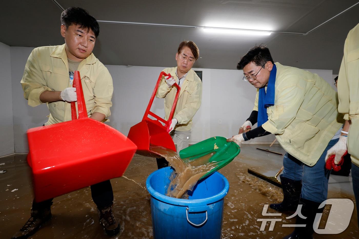박찬대 더불어민주당 당 대표 후보가 21일 폭우로 침수된 광주 서구 마륵동 한 가구점 지하에서 김이강 서구청장, 자원봉사자들과 함께 황토물을 제거하고 있다. 2025.7.21/뉴스1 ⓒ News1 김태성 기자