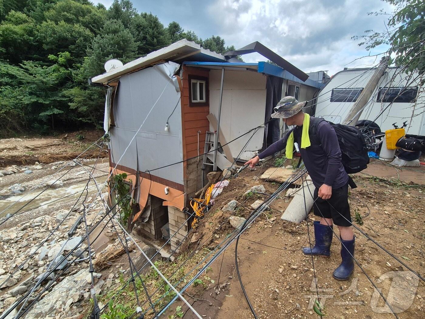 본문 이미지 - 21일 경기 가평군 조종면 마일1리 마을에서 주민이 위태롭게 서있는 주택을 가리키고 있다. 이곳은 전날 집중호우로 큰 피해를 입은 지역이다.2025.7.21/뉴스1 ⓒ News1 양희문 기자