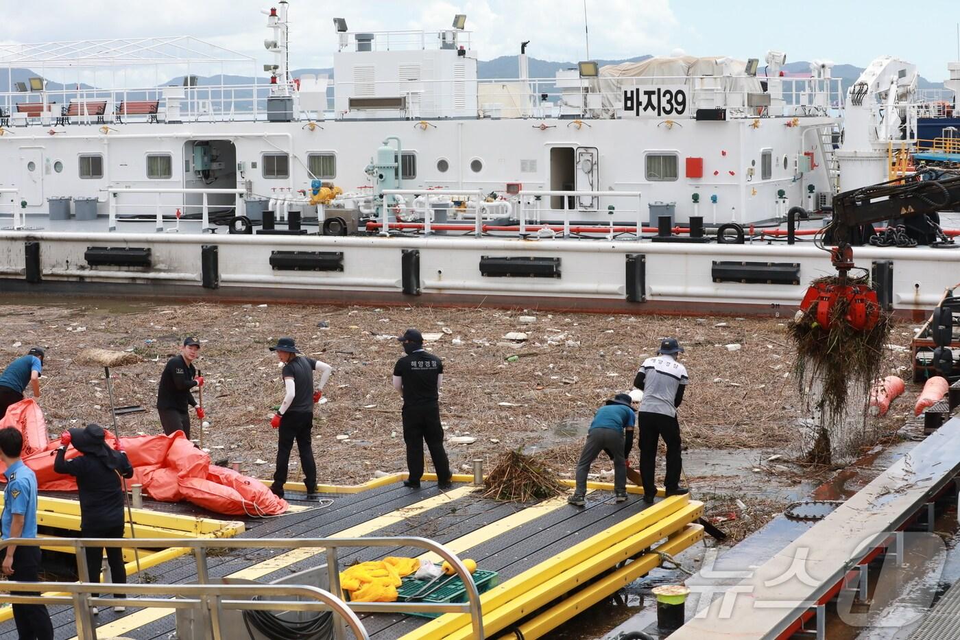 목포해양경찰이 21일 기록적 극한호우로 인해 해안가로 떠밀려온 해양 쓰레기 정화 작업을 하고 있다. (목포해경 제공. 재판매 및 DB 금지)