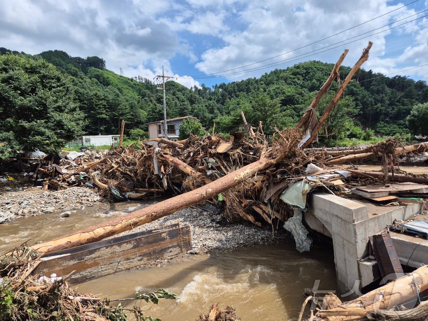 본문 이미지 - 21일 경기 가평군 조종면 마일1리가 전날 발생한 산사태로 전봇대가 쓰러지고 도로가 유실되는 등 큰 피해를 입었다. 2025.7.21/뉴스1 ⓒ News1 양희문 기자