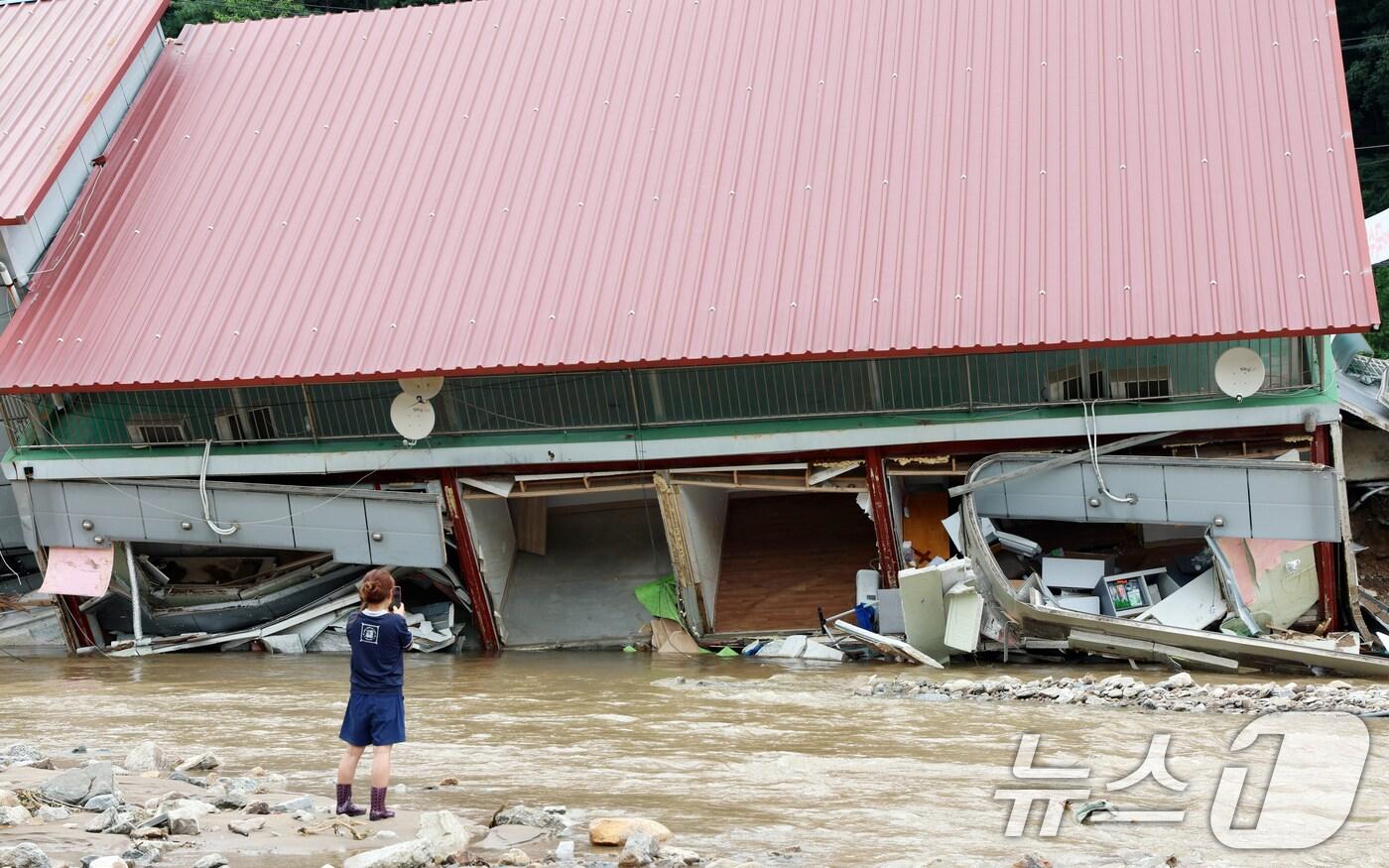 21일 오후 경기도 가평군 조종면 수해지역에서 가게 종업원이 무너지 상가 건물을 보고 있다. 2025.7.21/뉴스1 ⓒ News1 김명섭 기자