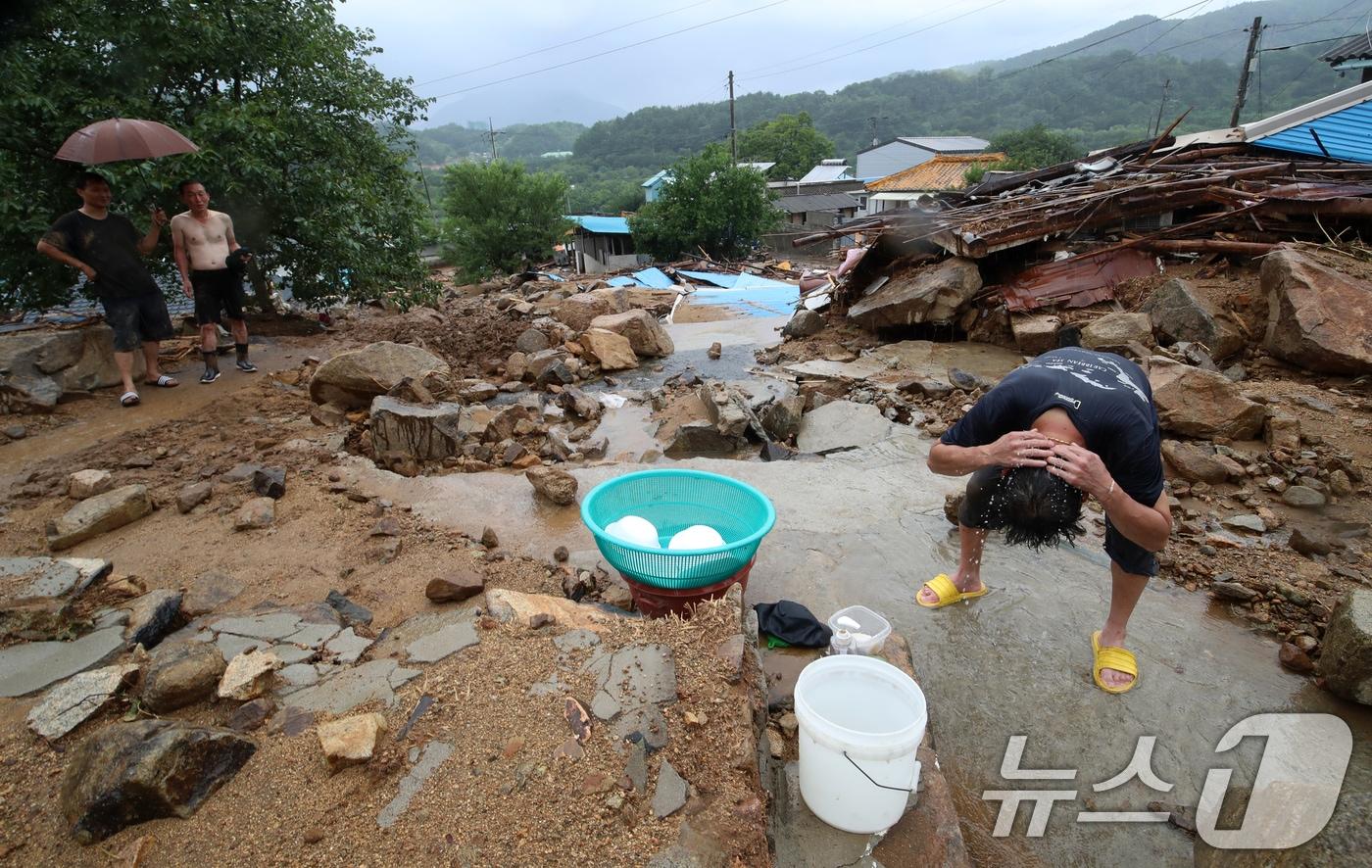21일 경남 산청군 산청읍 병정마을에서 주민과 자원봉사자가 수해 복구작업 중 흐르는 물로 머리를 씻고 있다. 2025.7.21/뉴스1 ⓒ News1 윤일지 기자