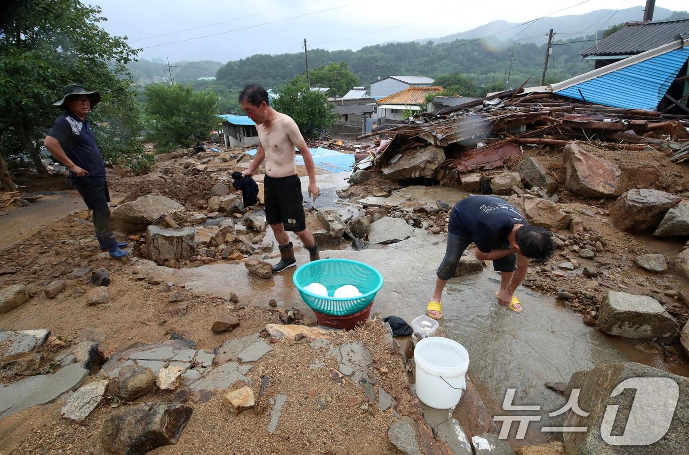 21일 경남 산청군 산청읍 병정마을에서 주민들과 자원봉사자가 수해 복구작업 중 흐르는 물로 씻고 있다. 2025.7.21/뉴스1 ⓒ News1 윤일지 기자