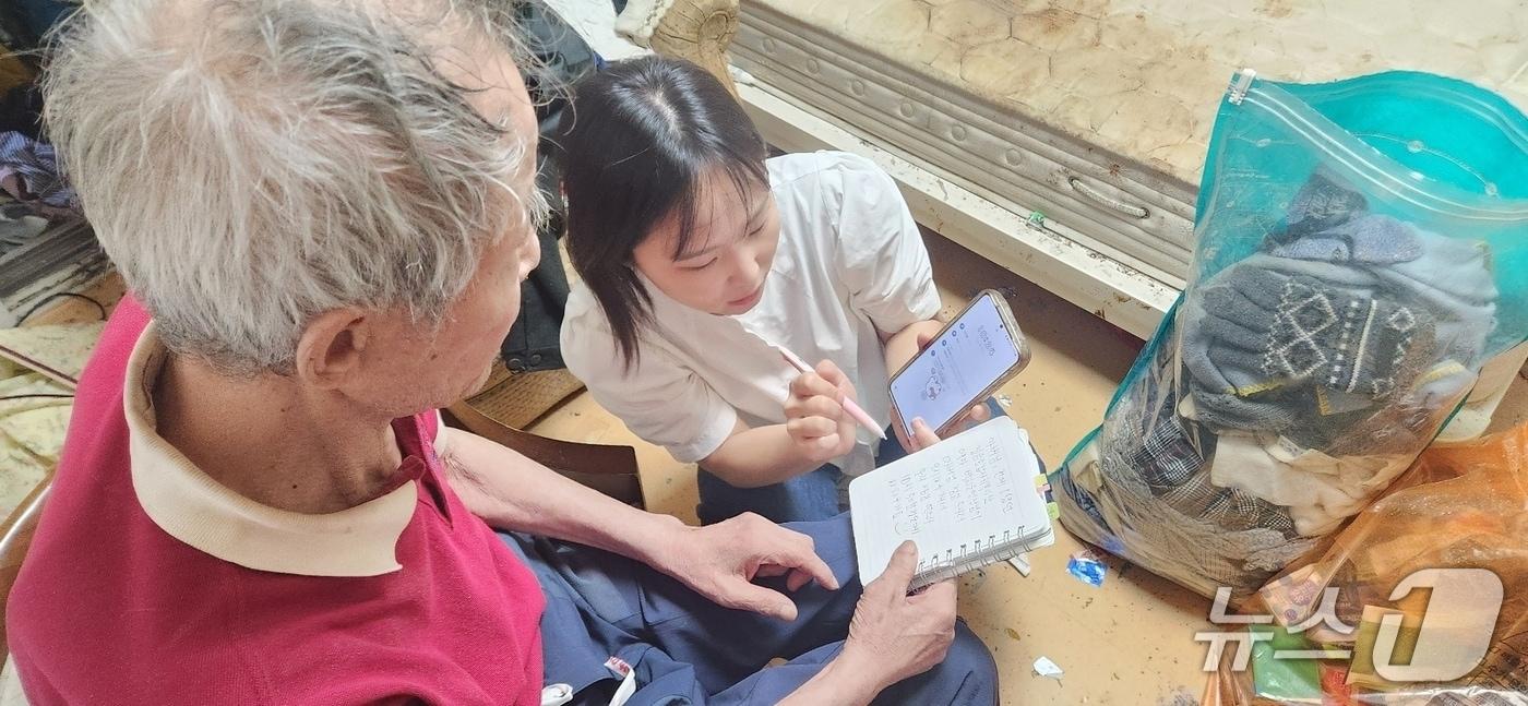 돈암1동 주민센터 사례관리 담당자가 청각장애와 치매로 일상생활이 불가해진 A씨와 필담으로 소통하고 있다.(성북구 제공)