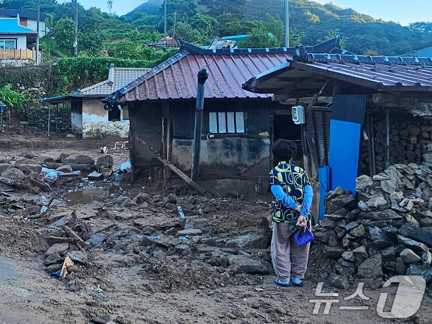 본문 이미지 - 22일 경남 산청군 율현마을 산사태 실종자의 아내 전인호 씨(74)가 자신의 집과 주변을 살펴보며 실종된 남편을 찾고 있다. 2025.7.22/뉴스1 ⓒ News1 한송학 기자