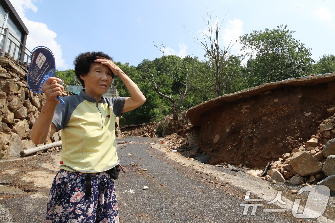22일 폭우와 산사태 피해를 입은 경남 산청군 산청읍 가촌마을 주민 김월자(76) 어르신이 쑥대밭이 된 마을을 둘러보며 부채로 더위를 식혀보고 있다. 이날 산청군에는 폭염주의보가 발효 중이다. 2025.7.22/뉴스1 ⓒ News1 윤일지 기자