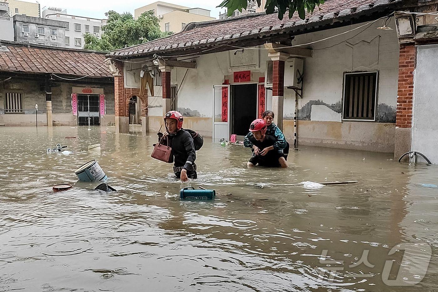 구조대원들이 11일(현지시간) 중국 남동부 샤먼성에서 폭우로 침수된 집에서 사람들을 구조하고 있다. 2025.7.11 . (특정 기사 내용과는 무관한 자료사진) ⓒ AFP=뉴스1 ⓒ News1 김경민 기자