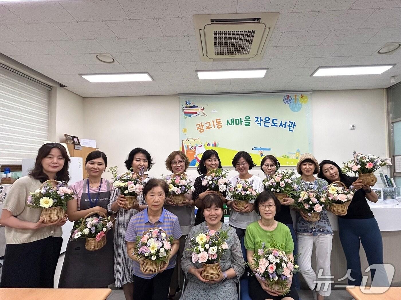 본문 이미지 - 경기 수원시 영통구 광교1동 새마을문고회가 22일 회원과 주민을 대상으로 '힐링 꽃꽂이 교실'을 진행한 후 기념촬영을 하고 있다. (광교1동 제공. 재판매 및 DB 금지) 2025.7.22/뉴스1
