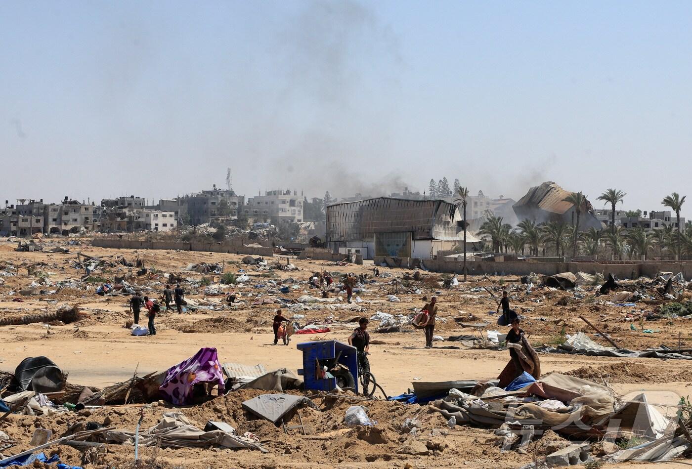 22일(현지시간) 가자지구 중부 데이르알발라에서 팔레스타인 피란민들이 이스라엘군의 공격으로 피해를 입은 대피소를 살펴보고 있다. 2025.07.22. ⓒ 로이터=뉴스1 ⓒ News1 윤다정 기자