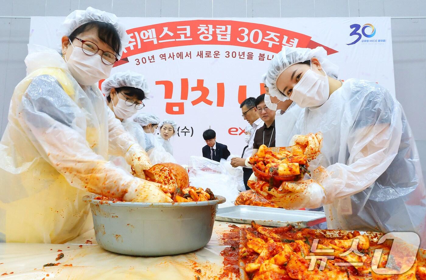 23일 오후 대구 북구 엑스코(EXCO) 전시장에서 열린 '엑스코 창립 30주년 기념 사랑의 김치 나눔'에 참여한 엑스코 임직원과 산격동 가정종합사회복지관 자원봉사자들이 절임 무에 김치 양념을 버무리고 있다. (엑스코 제공. 재판매 및 DB금지) 2025.7.23/뉴스1 ⓒ News1