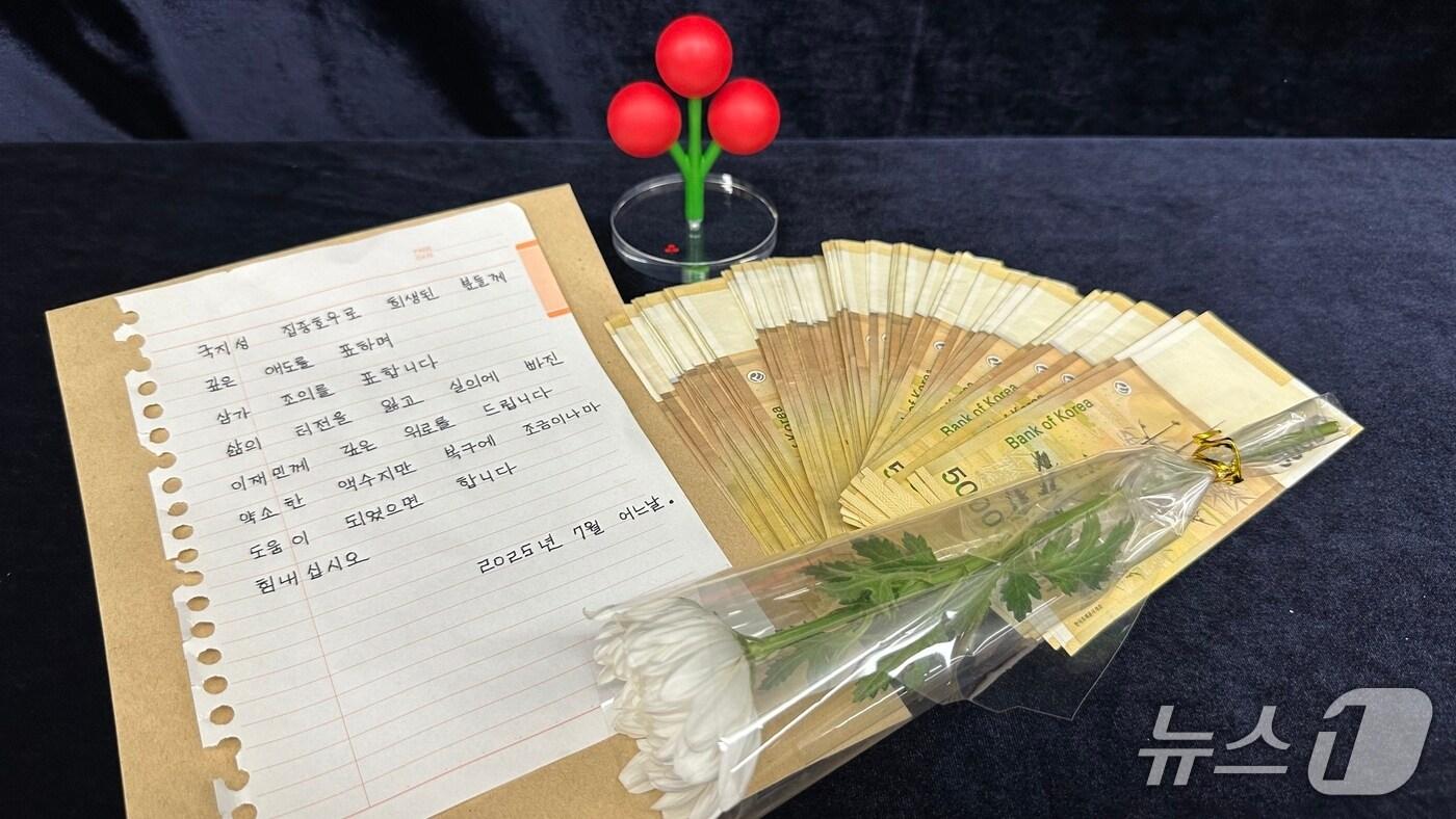 경남 익명의 나눔천사가 지난 22일 경남사회복지공동모금회 사무실 앞에 두고간 현금 500만원과 국화꽃 한 송이, 손편지 모습(경남사회복지공동모금회 제공. 재판매 및 DB금지)