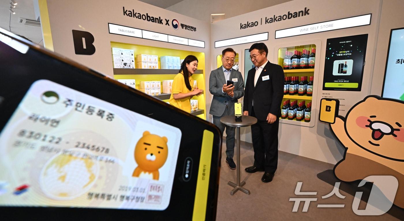 본문 이미지 - 윤호중 행정안전부 장관이 23일 서울 성동구 앤더슨씨에서 열린 2025년 모바일 신분증 민간개방 오픈 행사에서 윤호영 카카오뱅크 대표와 카카오뱅크 모바일신분증 서비스를 체험하고 있다. (공동취재) 2025.7.23 ⓒ 뉴스1 김성진 기자