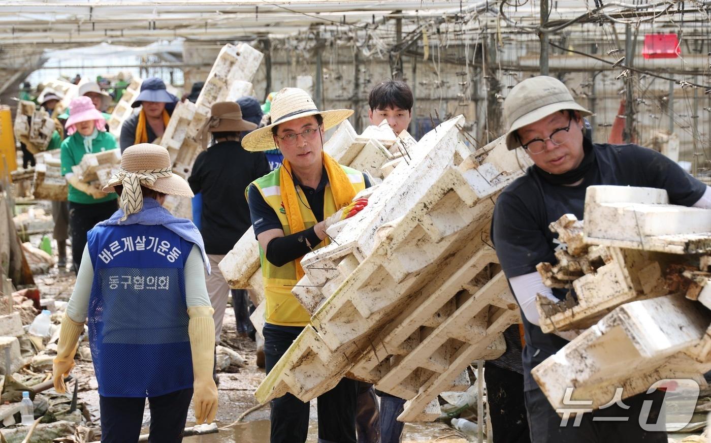 박희조 대전 동구청장과 자원봉사자들이 23일 충남 예산군 수해복구 현장에서 봉사활동을 하고 있다.(대전 동구 제공. 재판매 및 DB금지)/뉴스1