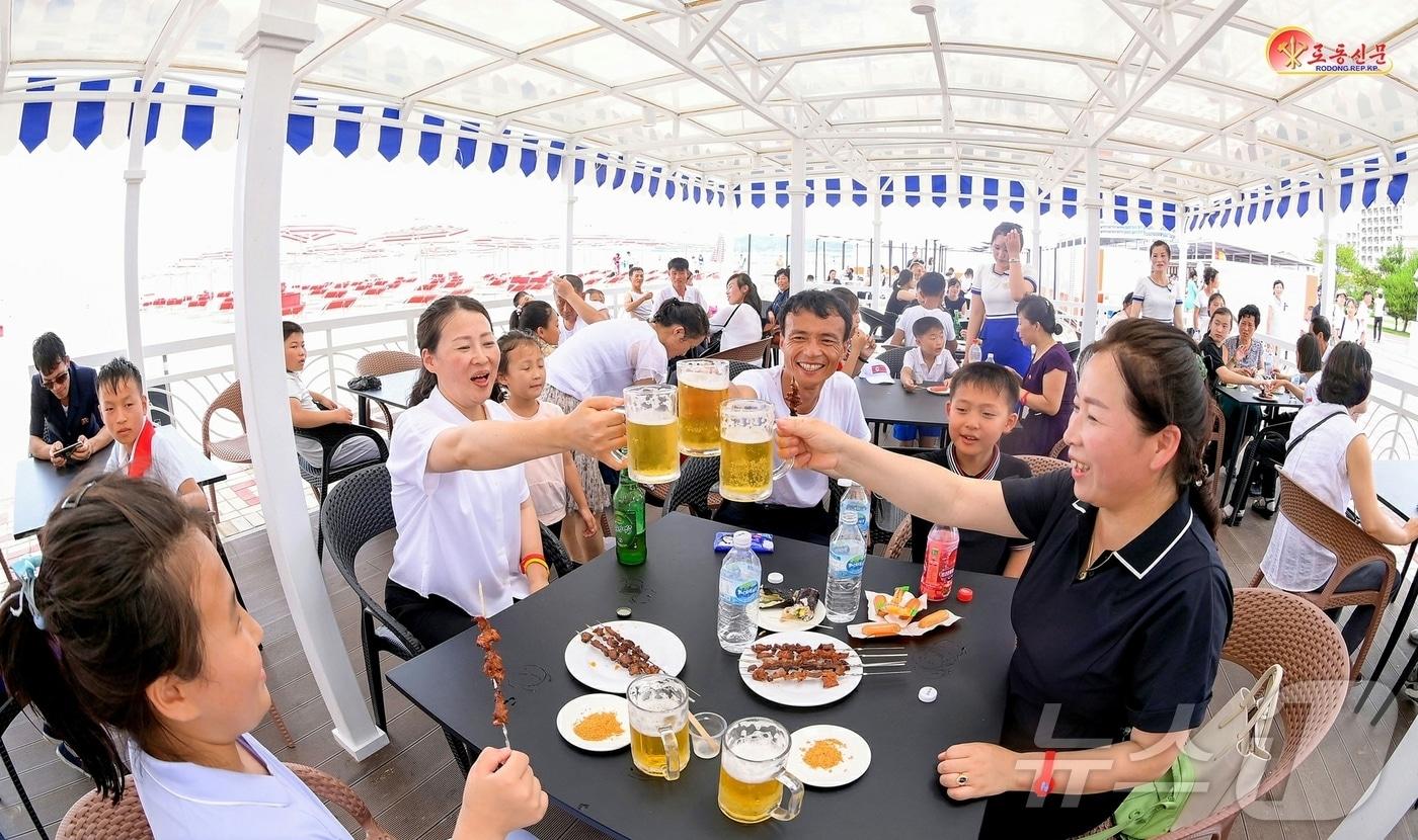 (평양 노동신문=뉴스1) = 원산 갈마해안관광지구는 해수욕장에서 맥주 마시는 북한 주민들. [국내에서만 사용가능. 재배포 금지. DB 금지. For Use Only in the Republic of Korea. Redistribution Prohibited] rodongphoto@news1.kr