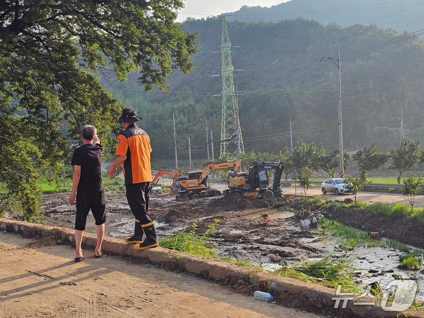 본문 이미지 - 24일 산청군 신등면 율현리 산사태 실종자를 찾기 위해 구조대원과 주민이 수색 장소에 대해 대화를 나누고 있다. 2025.7.24/뉴스1 한송학기자