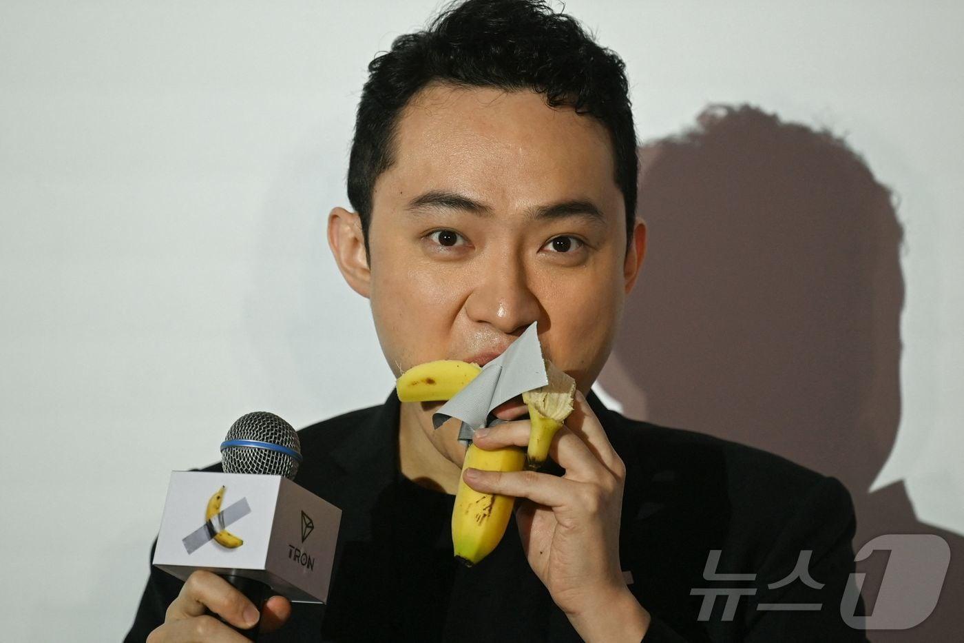 중국 태생의 암호화폐 창업자 저스틴쑨이 2024년 11월 29일 홍콩에서 신선한 바나나를 덕트 테이프로 벽에 붙인 바나나 예술 작품 '코미디언'을 먹고 있다. 그는 이탈리아 예술가 마우리치오 카텔란이 만든 이 도발적인 개념 미술 작품을 뉴욕 경매에서 620만 달러에 구입했다. 2024.11.29 ⓒ AFP=뉴스1 ⓒ News1 강민경 기자