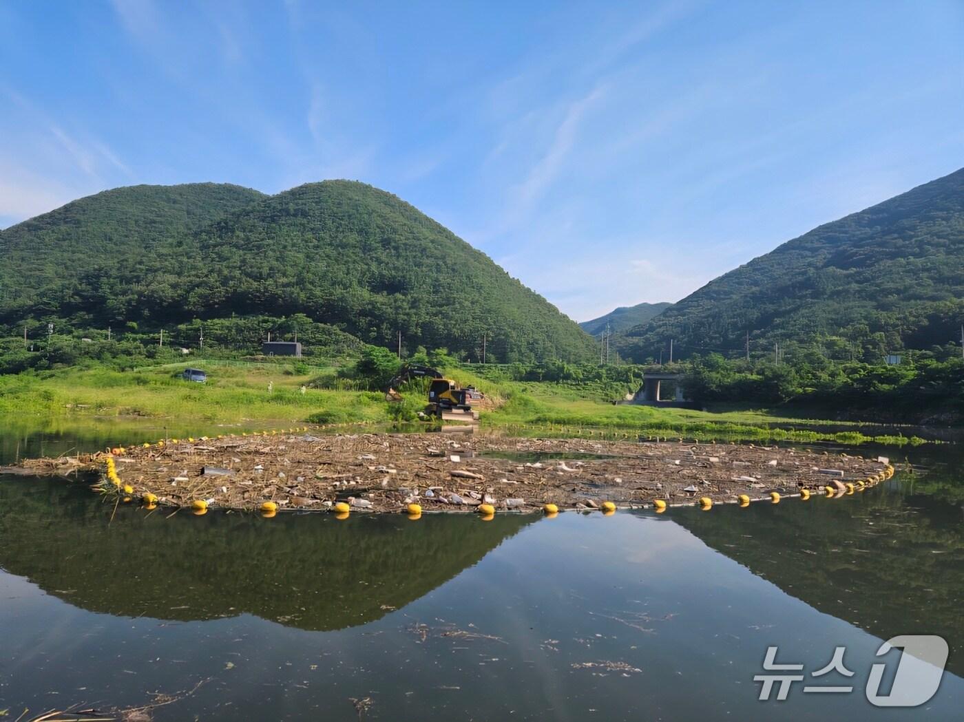 본문 이미지 - 23일 경북 영천 보현산댐 상류 일대 부유물 포집 모습. 포집된 부유물은 굴삭기를 동원해 운반 후 선별작업 등을 거쳐 처리될 예정이다.(한국수자원공사 제공.재판매 및 DB금지)/뉴스1