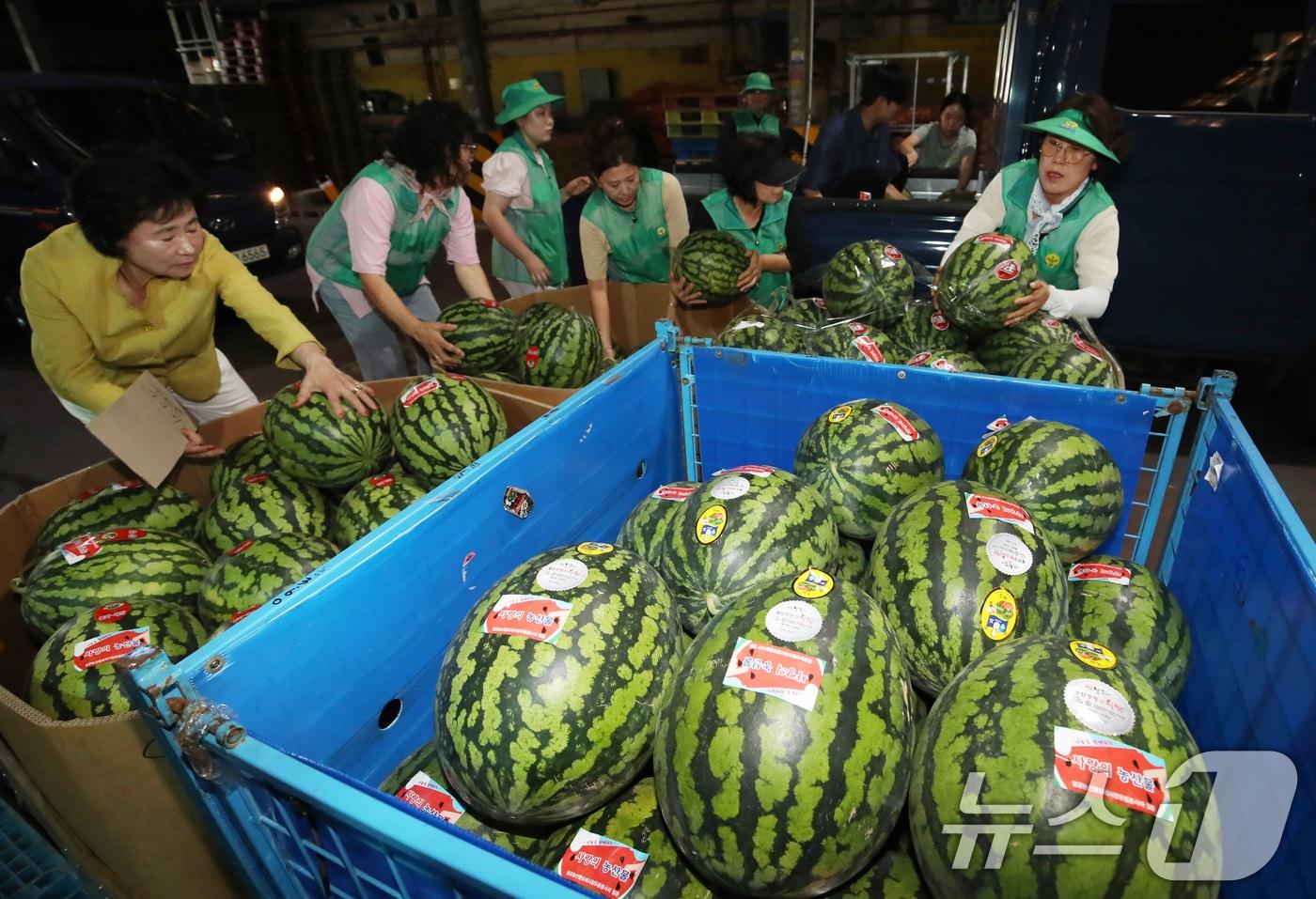 24일 오전 부산 사상구 엄궁농산물도매시장에서 열린 '2025년 시원한 여름나기 수박 나눔행사'에서 도매시장 유통종사자들이 소외계층에 전달할 수박을 차량에 옮겨 싣고 있다.2025.7.24/뉴스1 ⓒ News1 윤일지 기자
