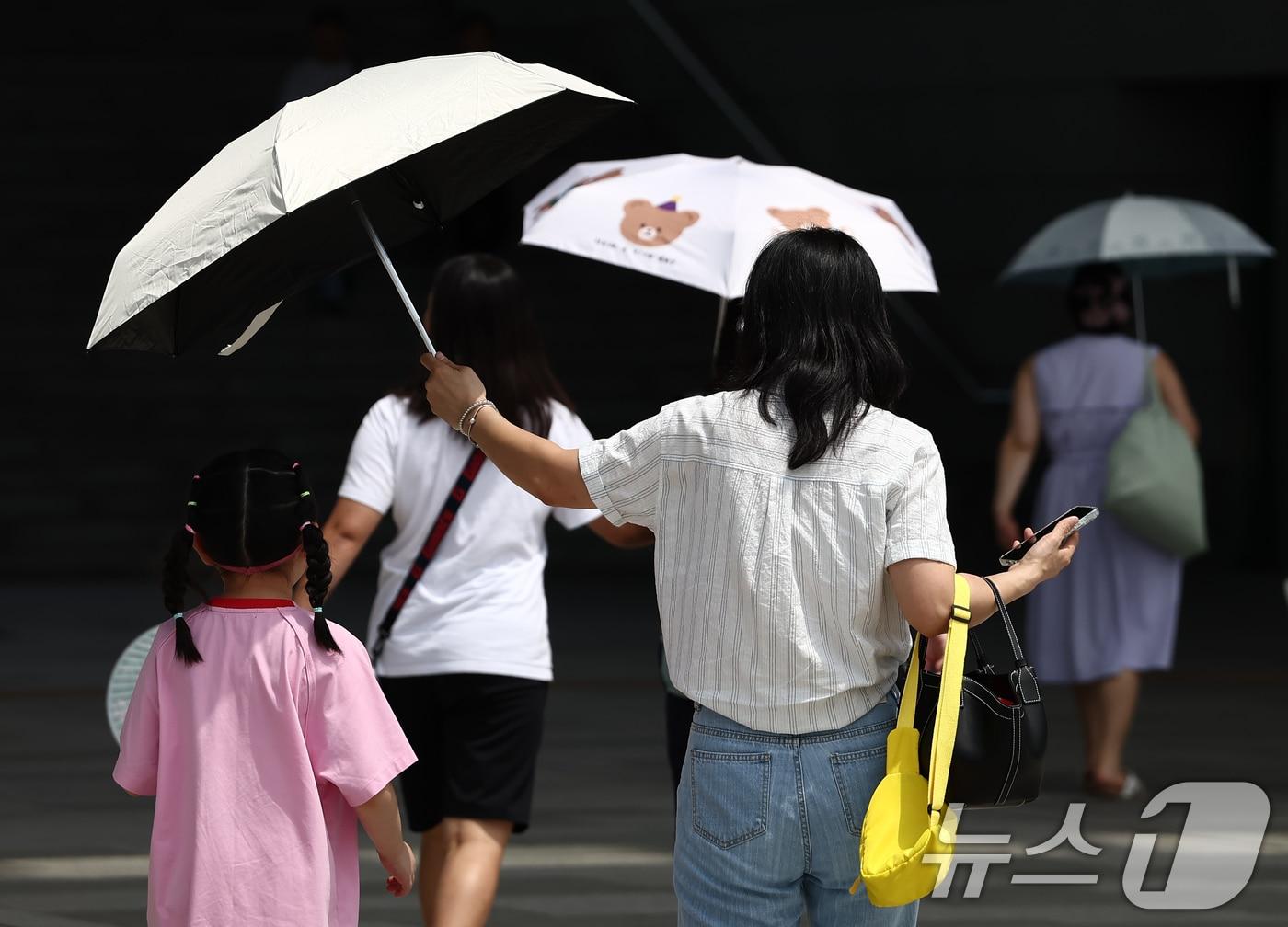 본문 이미지 - 서울 전역에 폭염경보가 내려진 24일 서울 용산구 국립중앙박물관에서 시민들이 양산을 쓰고 뜨거운 햇빛을 가리고 있다. 2025.7.24/뉴스1 ⓒ News1 김민지 기자