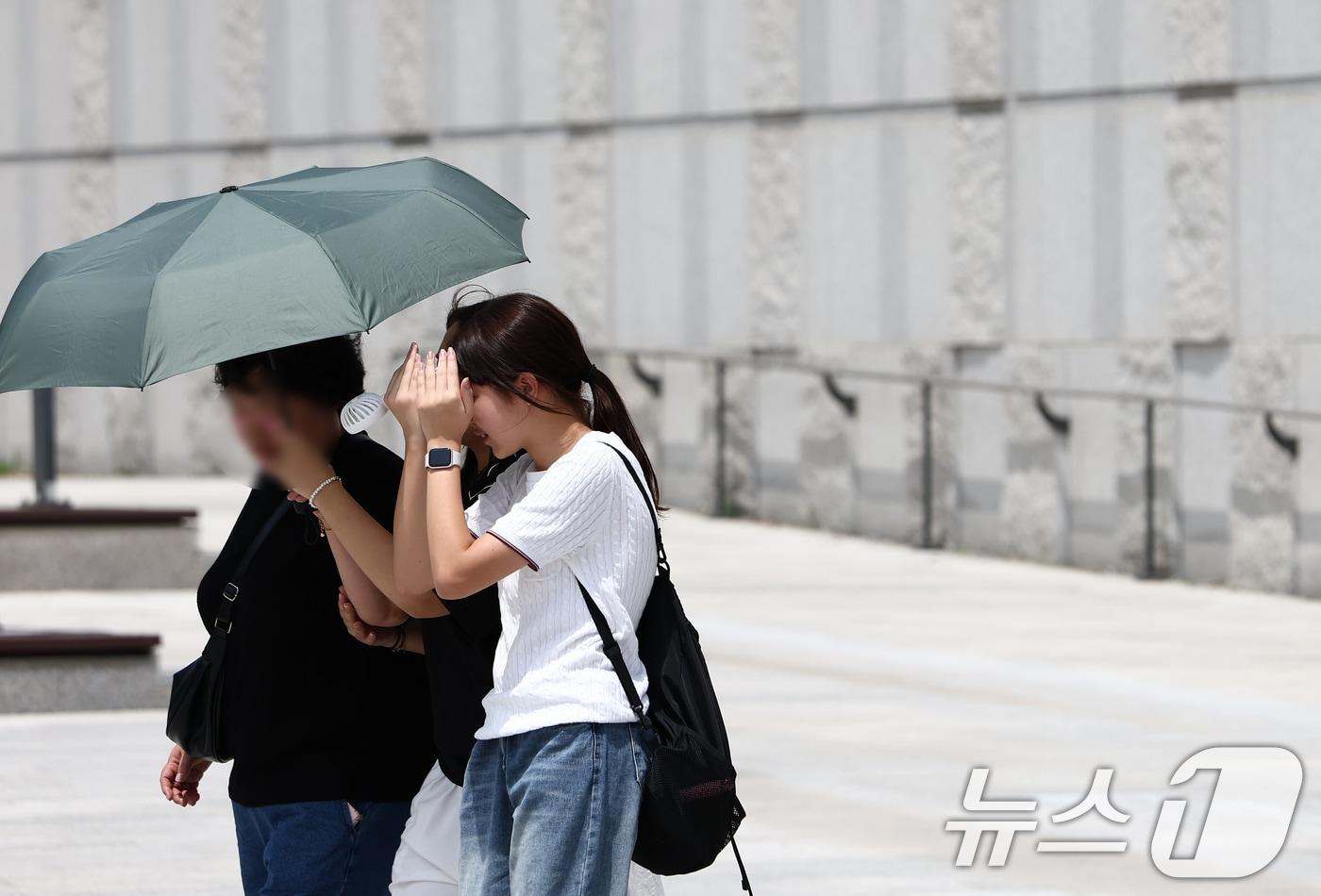 서울 전역에 폭염경보가 내려진 24일 서울 용산구 국립중앙박물관에서 시민들이 양산을 쓰고 뜨거운 햇빛을 가리고 있다. 2025.7.24/뉴스1 ⓒ News1 김민지 기자