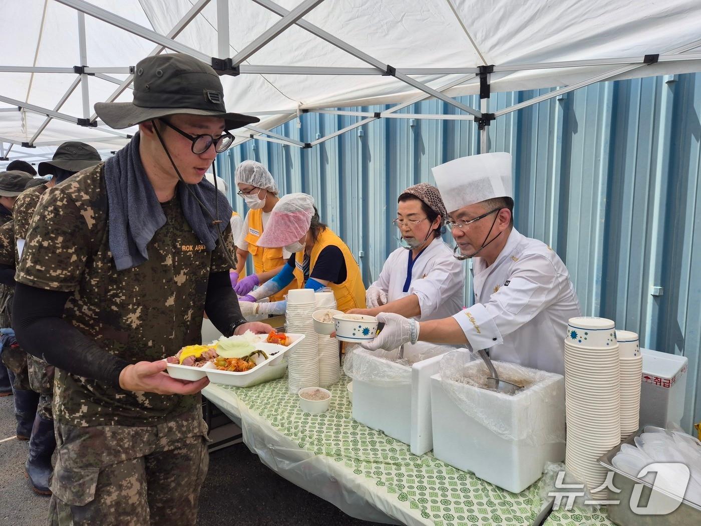 본문 이미지 - 24일 침수 피해 복구가 한창인 나주시 동강면 대지리 일대에서 &#39;흑백요리사&#39;로 알려진 안유성 셰프가 군 장병에게 식사를 전달하고 있다.&#40;대한적십자사 제공. 재판매 및 DB 금지&#41;