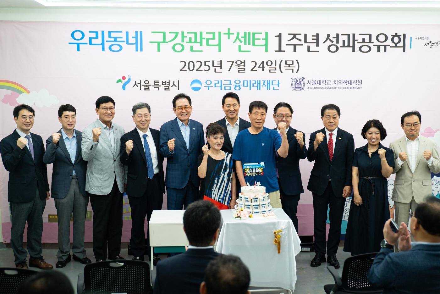 24일 우리동네 구강관리플러스센터에서 오세훈 서울시장&#40;가운데&#41;, 장광익 우리금융미래재단 사무국장&#40;왼쪽에서 다섯번째&#41;이 쪽방촌 주민들과 함께 1주년 기념떡을 컷팅하고 있다. &#40;우리금융그룹 제공&#41;