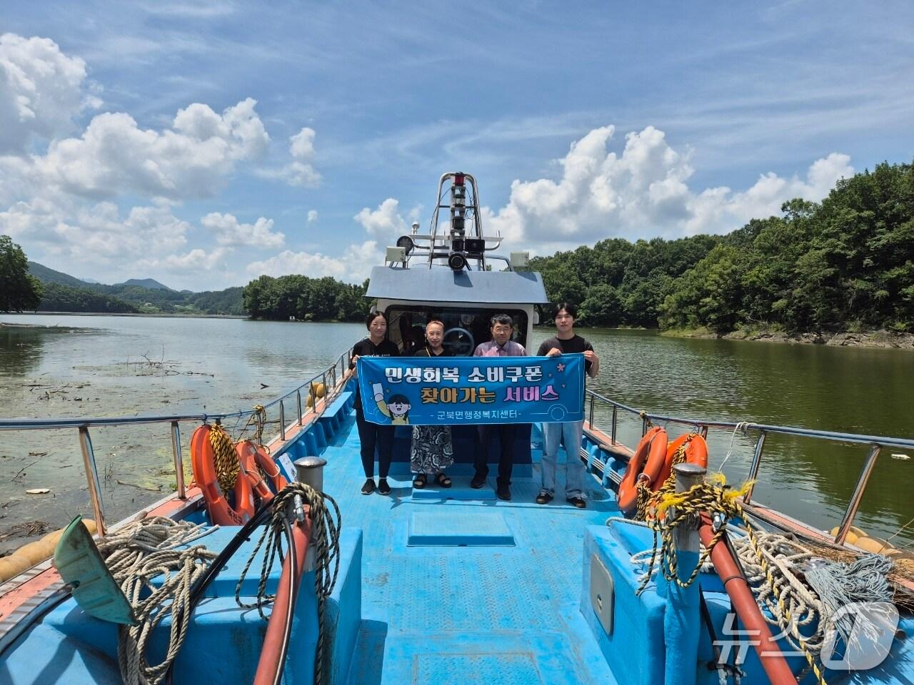 본문 이미지 - 옥천군 공무원들이 &#39;육지 속의 섬&#39;인 대청호 연안 군북면 막지리 주민들의 민생회복 소비쿠폰 신청 접수를 위해 도선을 타고 이동하고 있다.&#40;옥천군 제공, 재판매 및 DB금지&#41; /뉴스1 