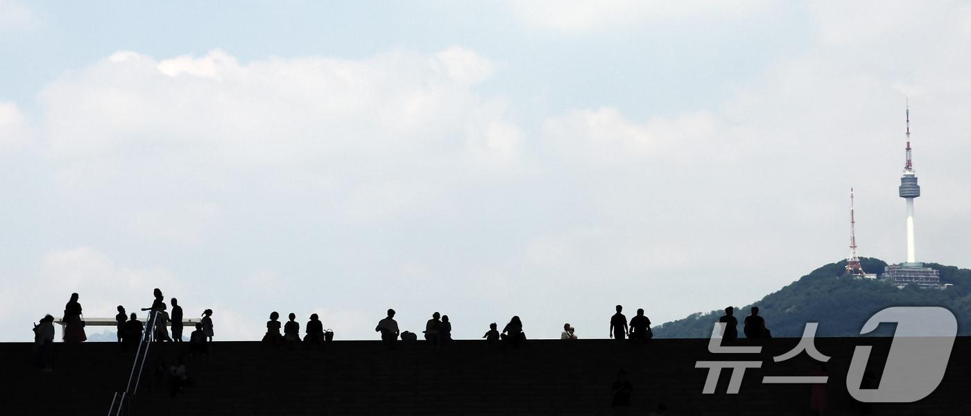 서울 전역에 폭염경보가 내려진 24일 서울 용산구 국립중앙박물관 계단에서 시민들이 파란 하늘을 보고 있다. 2025.7.24/뉴스1 ⓒ News1 김민지 기자