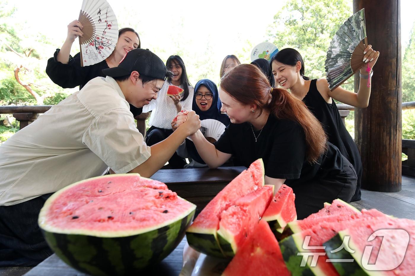 24일 오후 대구 달서구 계명대 성서캠퍼스 한학촌에서 열린 &#39;외국인 유학생 여름나기&#39; 행사에 참여한 학생들이 수박을 앞에 두고 팔씨름 한판을 벌이고 있다. 2025.7.24/뉴스1 ⓒ News1 공정식 기자