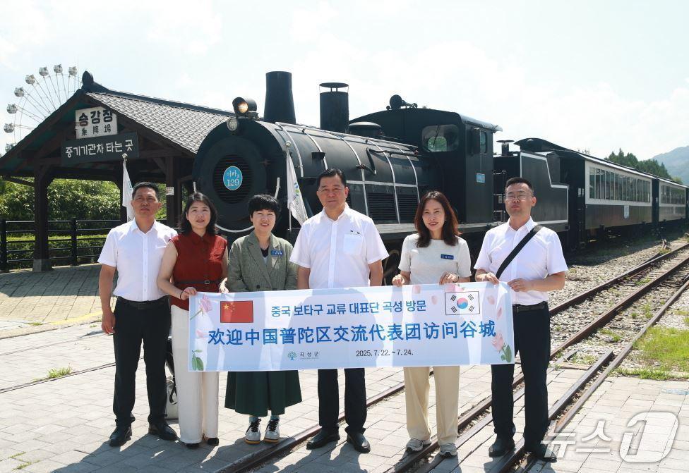 본문 이미지 - 곡성군을 방문한 중국 보타구 교류 대표단이 곡성기차마을에서 기념사진을 촬영하고 있다(곡성군 제공) 