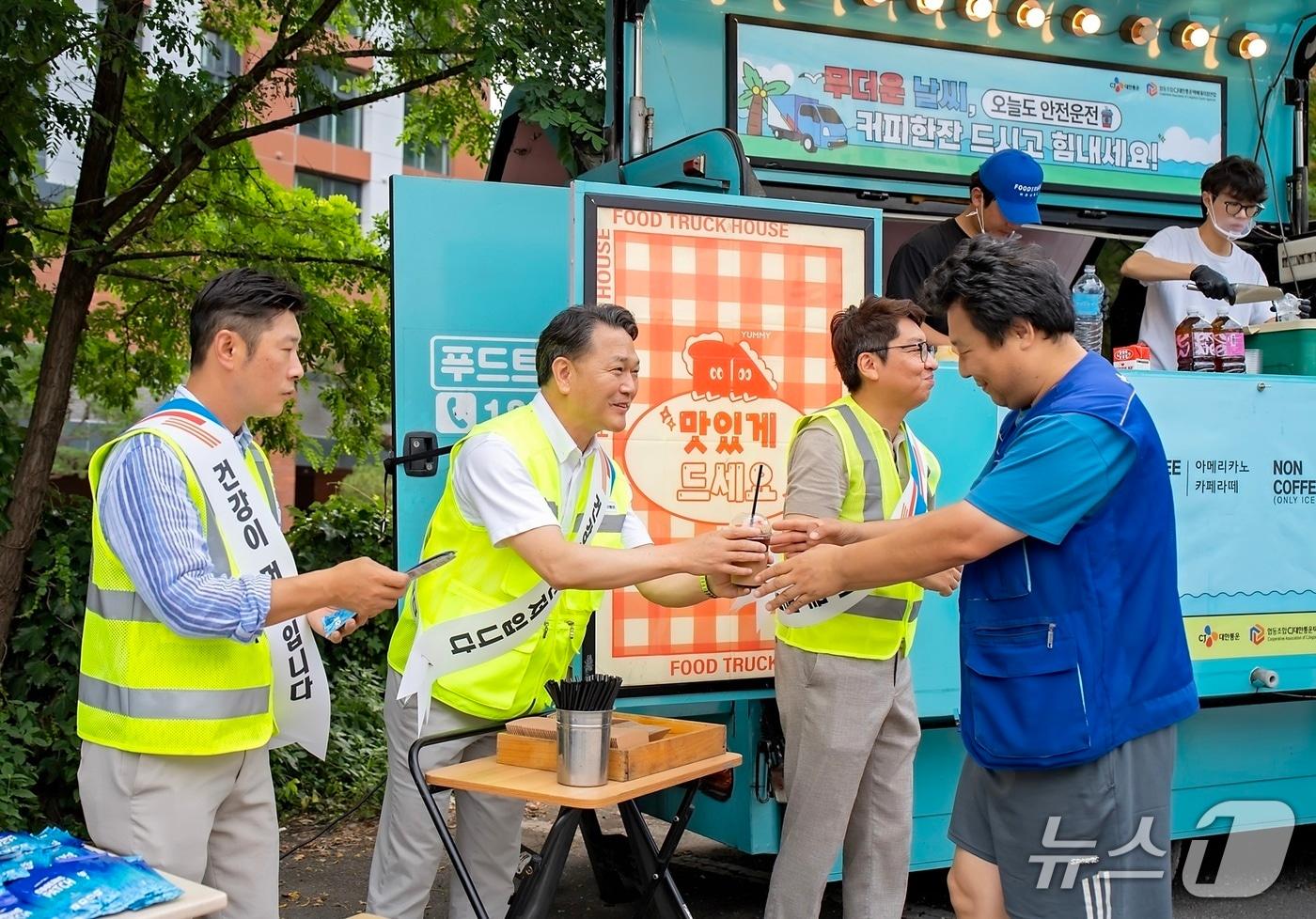 윤재승 CJ대한통운 O-NE 본부장(왼쪽에서 두 번째)이 24일 경기도 수원시 소재 CJ대한통운 서브터미널에서 택배기사에게 커피와 쿨링패치 등 여름나기 용품을 전달하고 있다. (CJ대한통운 제공)