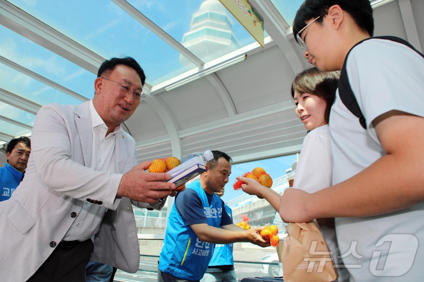 강동훈 제주특별자치도관광협회 회장&#40;왼쪽&#41;과 강동훈 제주특별자치도렌터카조합 이사장이 25일 오전 제주국제공항 렌터카 주차장 비가림 통로에서 렌터카 교통사고 예방 캠페인의 일환으로 관광객들에게 감귤과 생수, 치약·칫솔 세트를 전달하고 있다. 2025.7.25/뉴스1 ⓒ News1 오미란 기자
