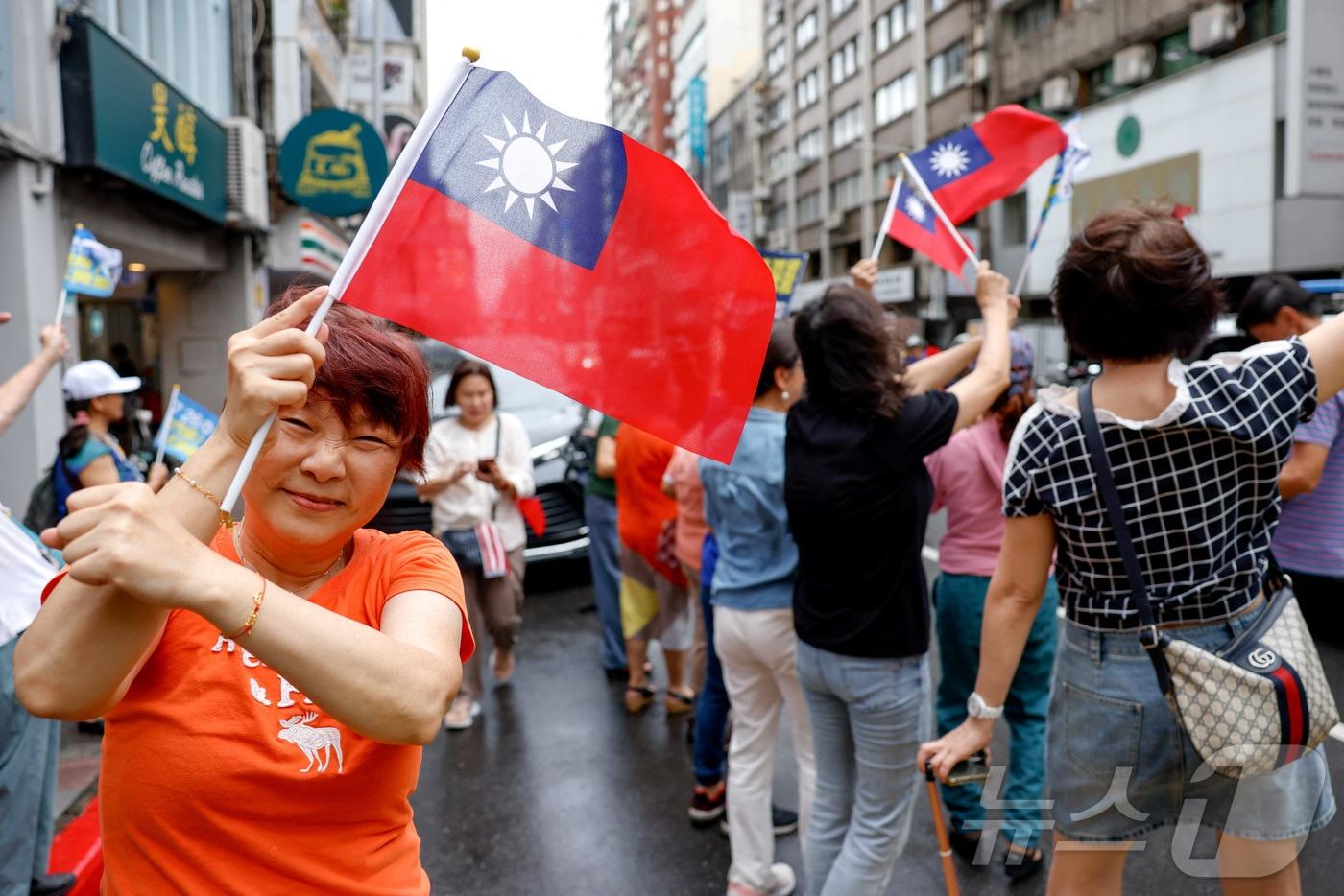 대만 의원 소환 투표에 반대하는 시민이 타이베이에서 대만 국기를 들고 포즈를 취하고 있다. 2025.7.24 ⓒ 로이터=뉴스1 ⓒ News1 정은지 특파원