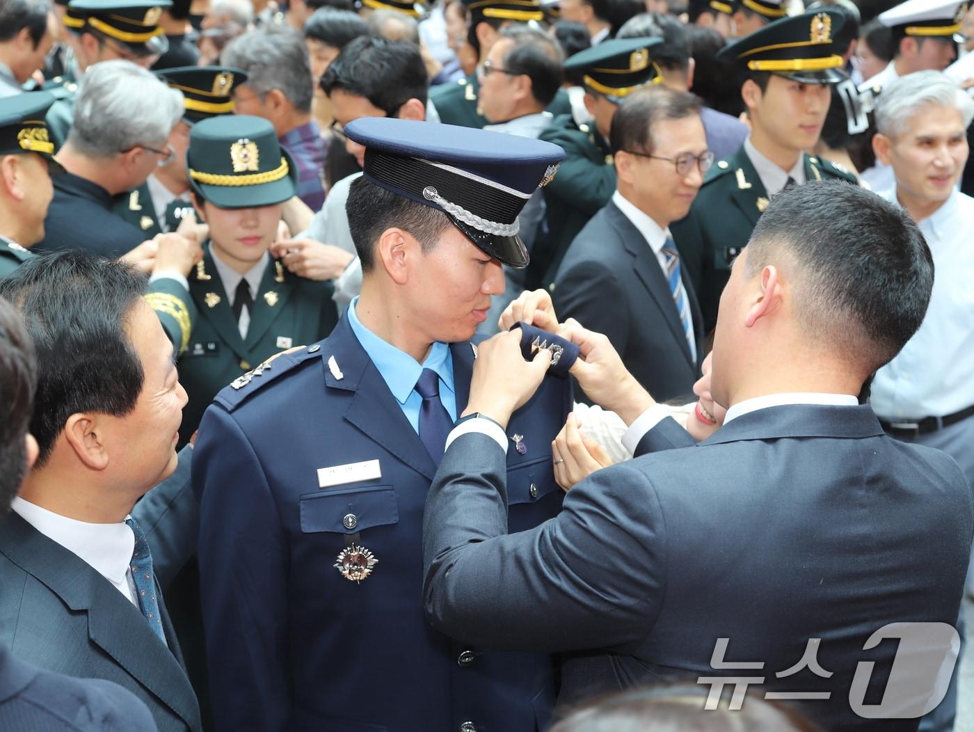 본문 이미지 - 육군은 25일 충북 영동에 위치한 육군종합행정학교에서 이두희 국방부 차관 주관으로 &#39;제99기 법무사관 임관식&#39;을 거행했다고 밝혔다. 임관장교들의 어깨에 가족들이 계급장을 부착하고 있다. &#40;육군 제공. 재판매 및 DB 금지&#41; 2025.7.25/뉴스1