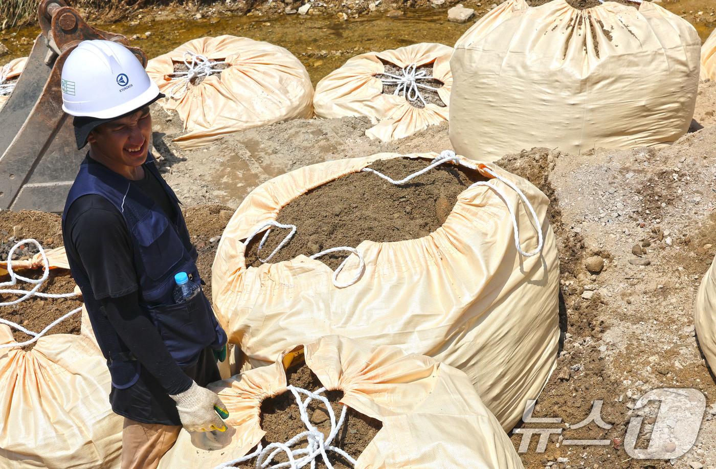 폭염경보가 내려진 지난 7월25일 현장관계자들이 폭우로 무너진 전남 담양군 금성면 가사 소하천의 제방을 다시 쌓아올리고 있다. 2025.7.25/뉴스1 ⓒ News1 박지현 기자