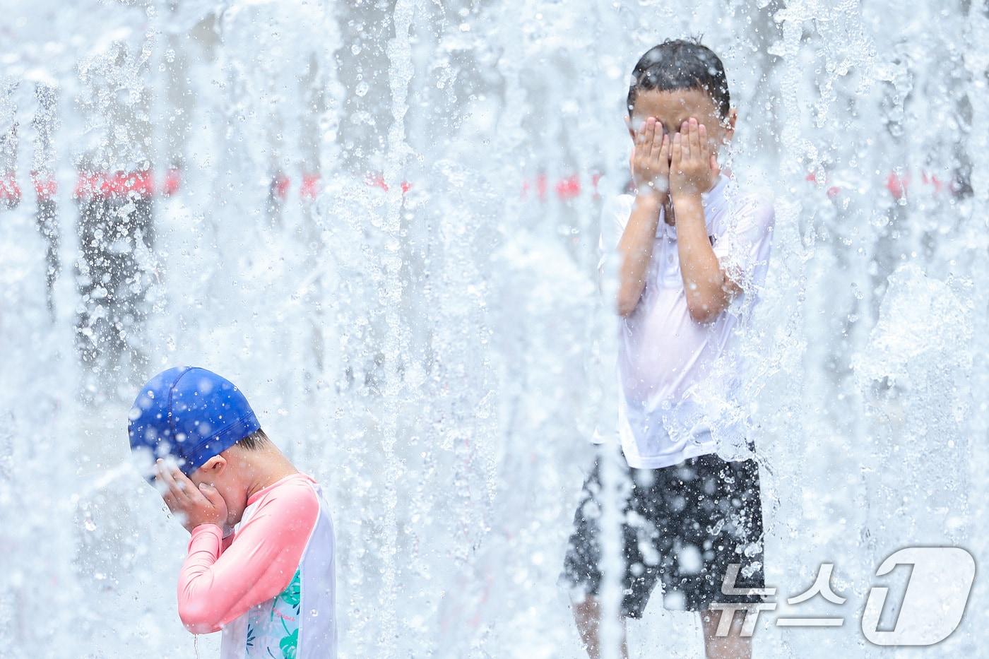 전국 대부분 지역에 폭염 경보가 발효된 25일 서울 광화문광장 바닥분수에서 한 어린이가 보호자와 함께 물놀이를 하며 더위를 식히고 있다. 기상청은 토요일인 오는 25일에는 서울 낮 최고기온이 38도까지 올라갈 것으로 예보했다. 2025.7.25/뉴스1 ⓒ News1 신웅수 기자