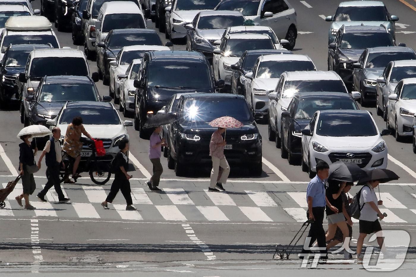 대구 중구 달구벌대로에서 양산을 쓴 시민들이 아지랑이가 피어오르는 도로를 건너고 있다. /뉴스1 ⓒ News1 공정식 기자