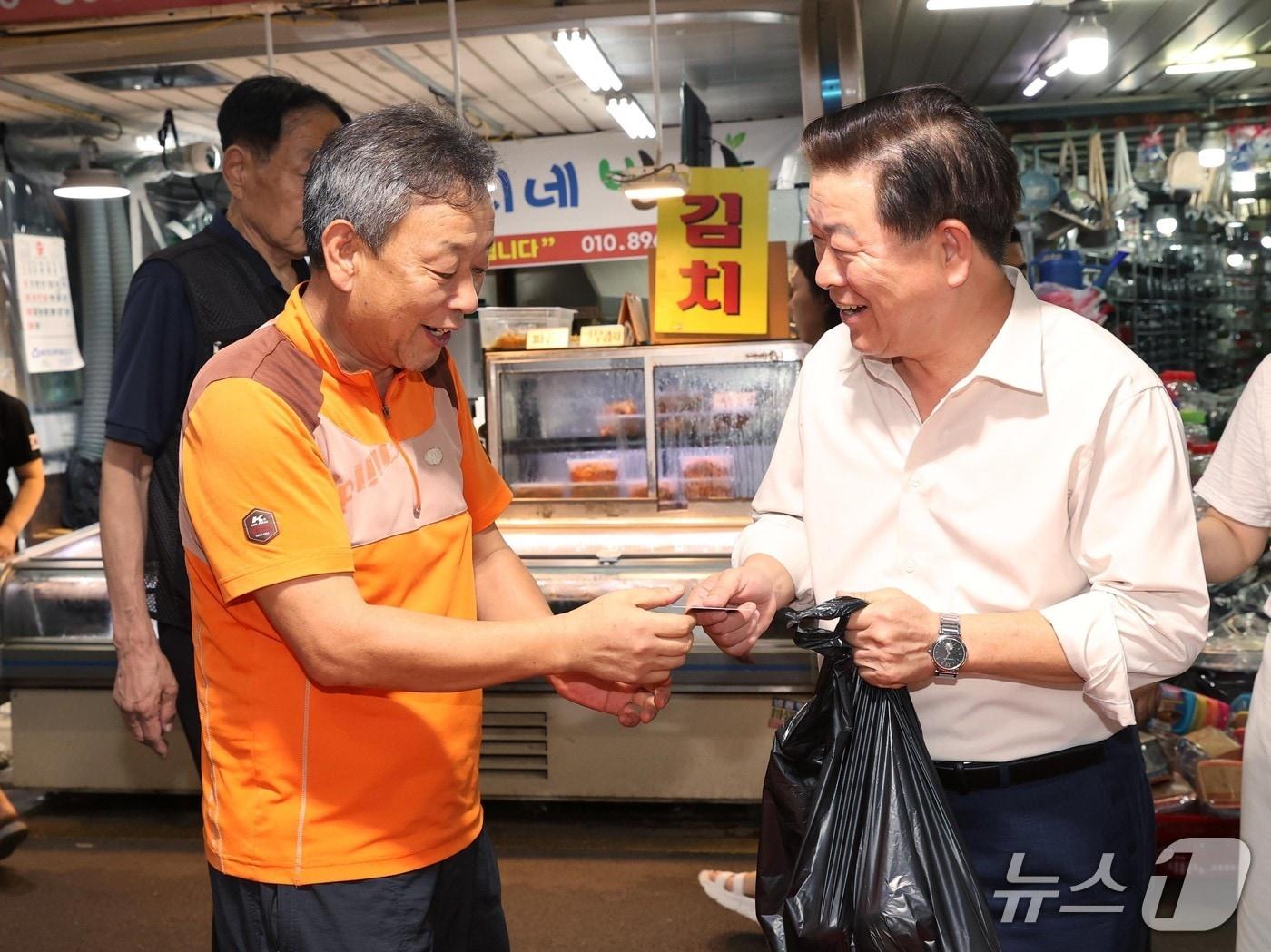 본문 이미지 - 박승원 광명시장(오른쪽)이 지난해 광명새마을시장을 방문해 광명사랑화폐로 물품을 구매하고 있다.(광명시 제공)