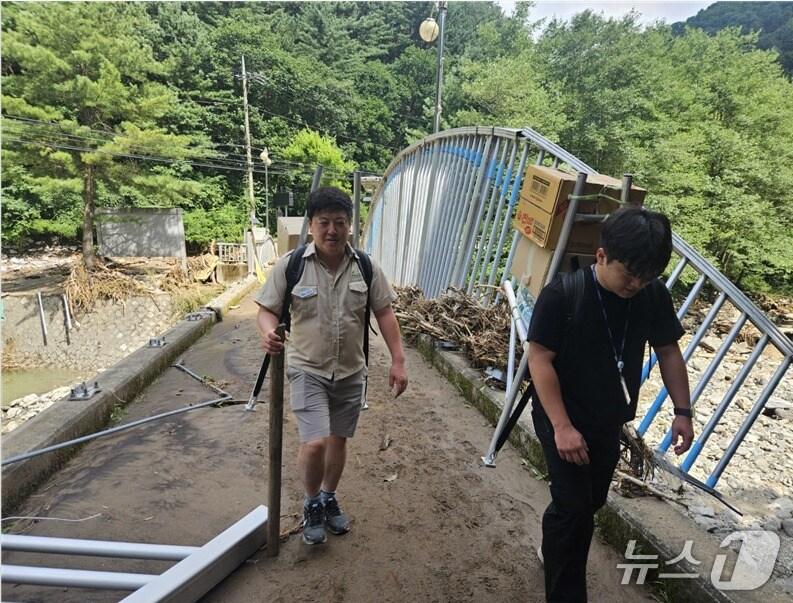 본문 이미지 -  경기 가평군에서 집중호우로 고립된 마을 주민을 위해 연인산도립공원 직원들이 지게에 긴급 구호물품을 싣고 마을을 오가고 있는 모습(경기도 제공, 재판매 및 DB 금지)/뉴스1