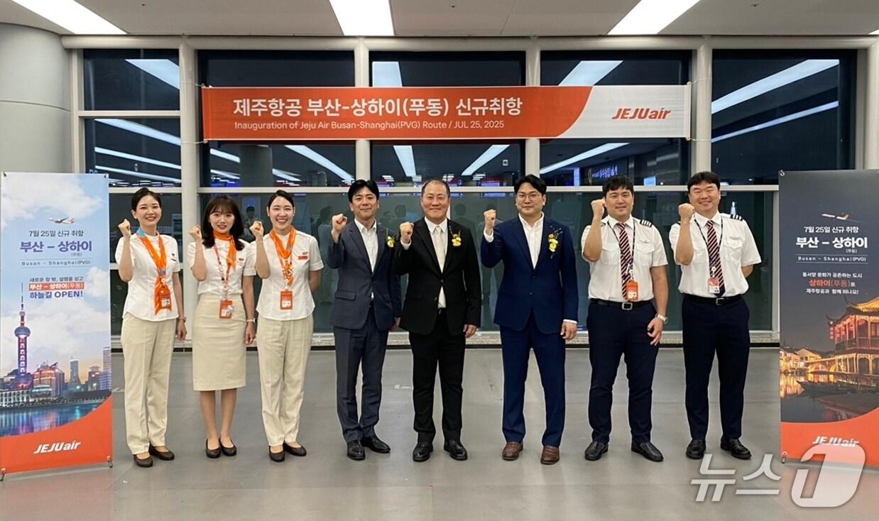 본문 이미지 - 지난 25일 김해국제공항에서 진행된 제주항공 부산-상하이(푸둥) 노선 신규 취항식에서 정재필 커머셜본부장(사진 오른쪽에서 네번째) 등 임직원들이 신규 취항편 승무원들과 기념촬영을 하고 있다. (제주항공 제공) 