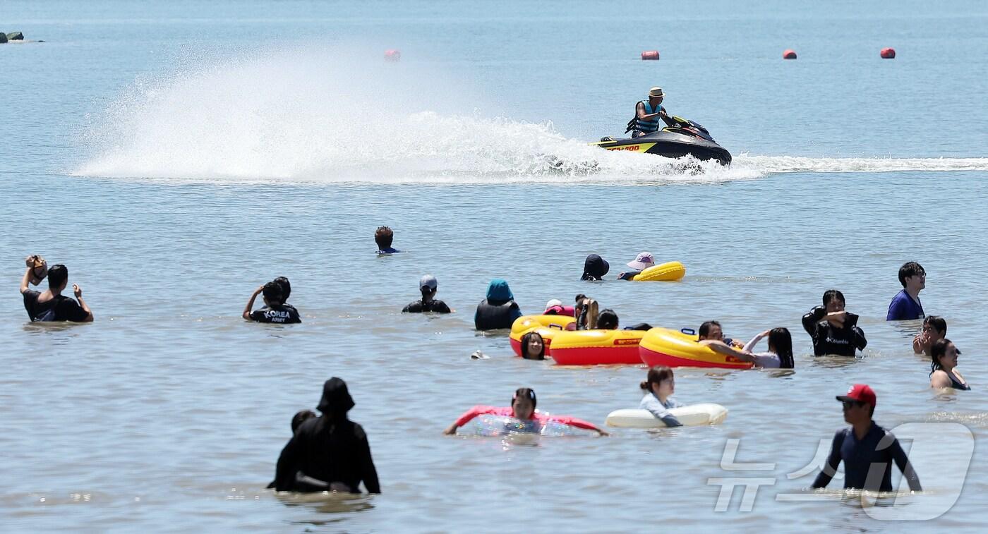 전국 대부분 지역에 폭염특보가 내려진 27일 오후 인천 중구 을왕리 해수욕장을 찾은 시민들이 더위를 식히고 있다. 2025.7.27/뉴스1 ⓒ News1 김진환 기자