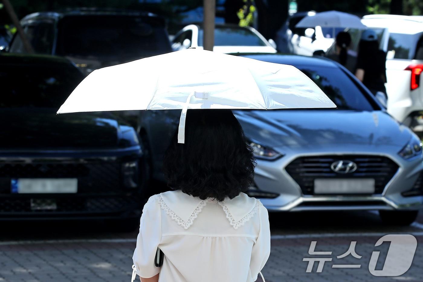 폭염이 이어진 28일 오전 대구 달서구청 민원실에서 한 시민이 &#39;양심양산&#39;을 빌려 뙤약볕을 가린 채 청사를 나서고 있다. 2025.7.28/뉴스1 ⓒ News1 공정식 기자