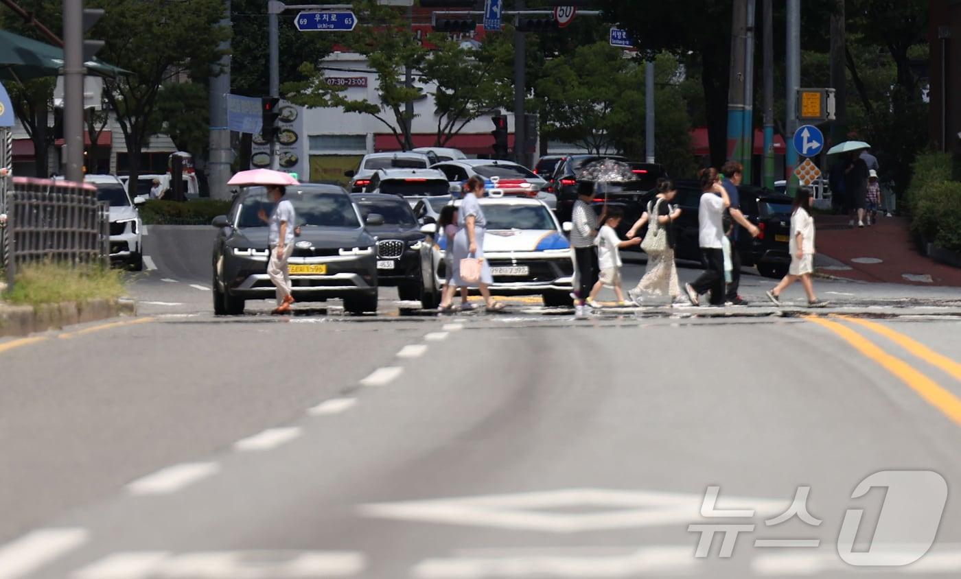 폭염경보가 발효된 지난 7월 시민들이 아지랑이가 피어오르고 있는 광주 북구청 사거리 신호등을 건너고 있다. 2025.7.28/뉴스1 ⓒ News1 박지현 기자